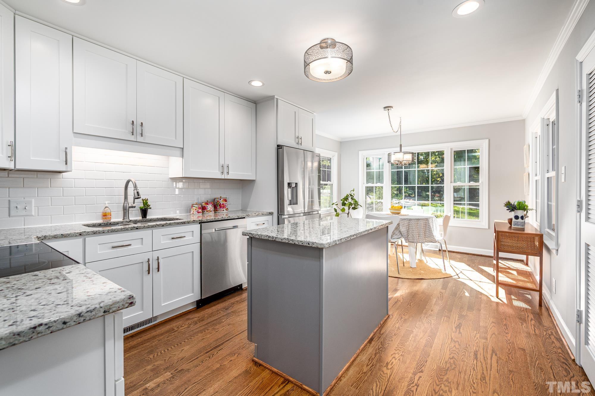 2910 Buckingham Road Durham, NC 27707 - Photo 12 of 30 a kitchen with stainless steel appliances granite countertop wooden floors and view living room