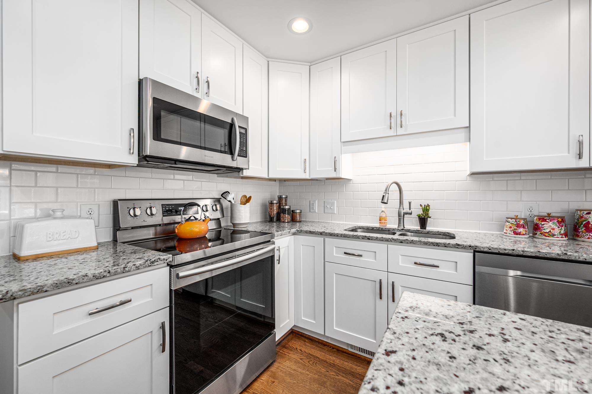 2910 Buckingham Road Durham, NC 27707 - Photo 13 of 30 a kitchen with stainless steel appliances granite countertop a sink stove and microwave