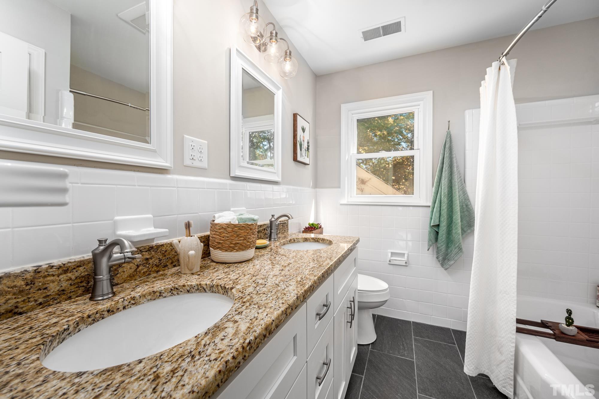 2910 Buckingham Road Durham, NC 27707 - Photo 24 of 30 a bathroom with a granite countertop double vanity sink and a mirror