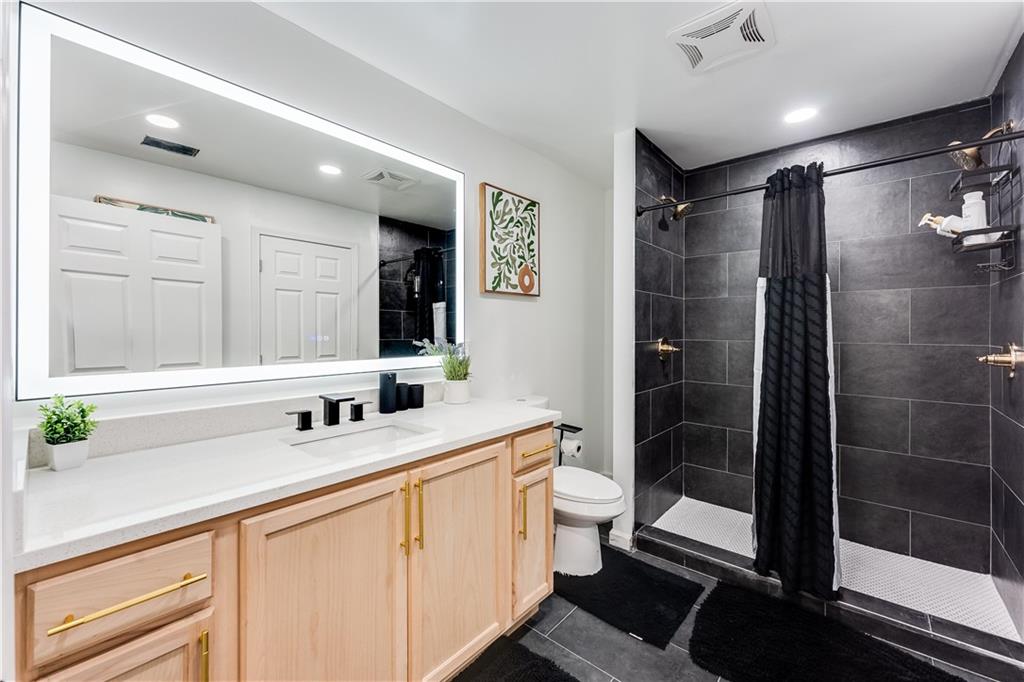 3135 Esplanade Circle Southwest Atlanta, GA 30311 - Photo 57 of 69 a bathroom with a double vanity sink toilet mirror and shower