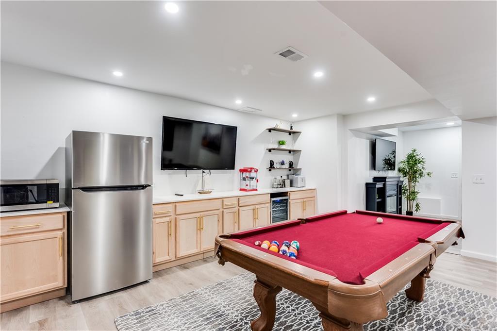 3135 Esplanade Circle Southwest Atlanta, GA 30311 - Photo 63 of 69 a kitchen with stainless steel appliances kitchen island granite countertop a refrigerator a stove a microwave oven with white cabinets and wooden floor