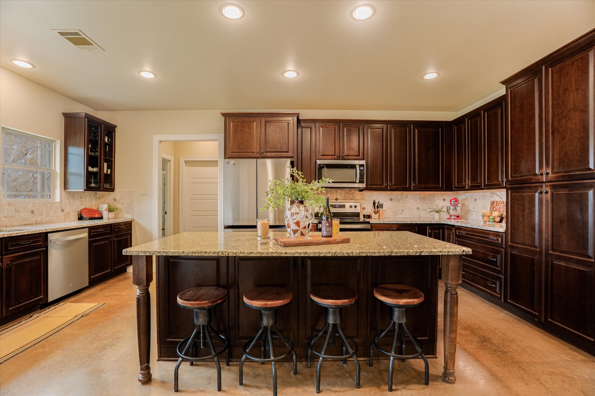 3501 Pursley Road Dripping Springs, TX 78620 - Photo 9 of 38 a kitchen with stainless steel appliances kitchen island granite countertop a dining table and chairs
