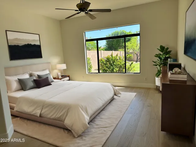a bedroom with a bed and a flat tv screen on dresser