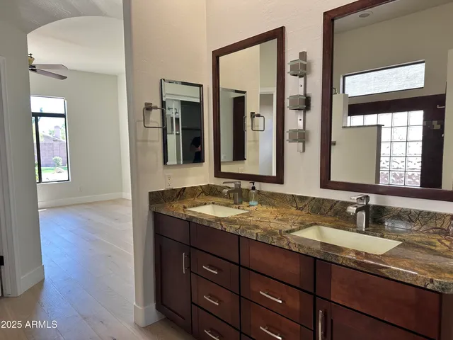 a bathroom with a granite countertop sink and a mirror