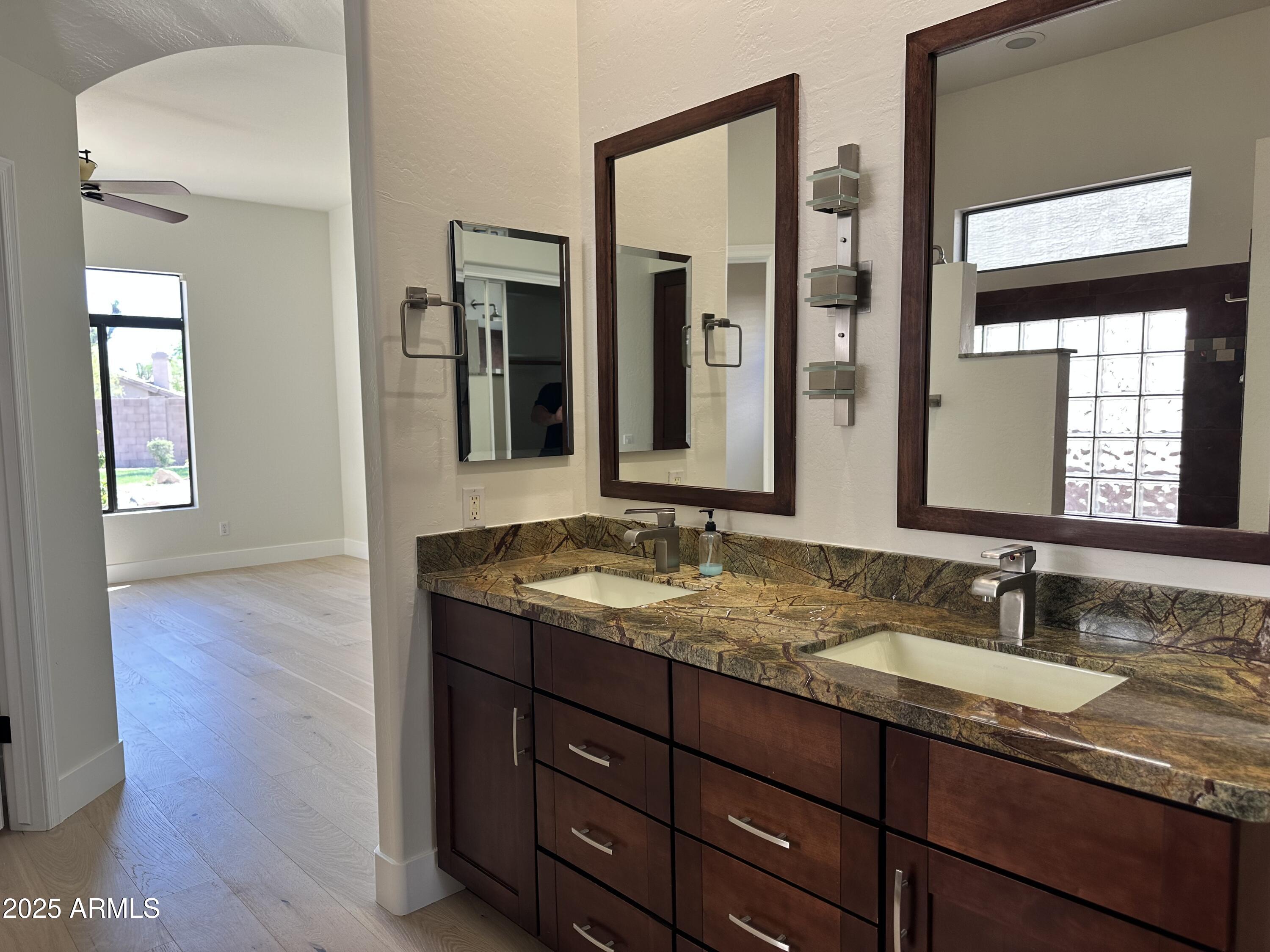 4303 East Hamblin Drive Phoenix, AZ 85050 - Photo 12 of 16 a bathroom with a granite countertop sink and a mirror