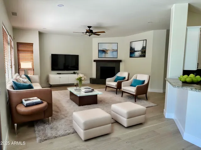 a living room with furniture a flat screen tv and a window