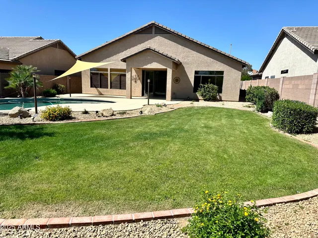 a front view of a house with a yard and potted plants