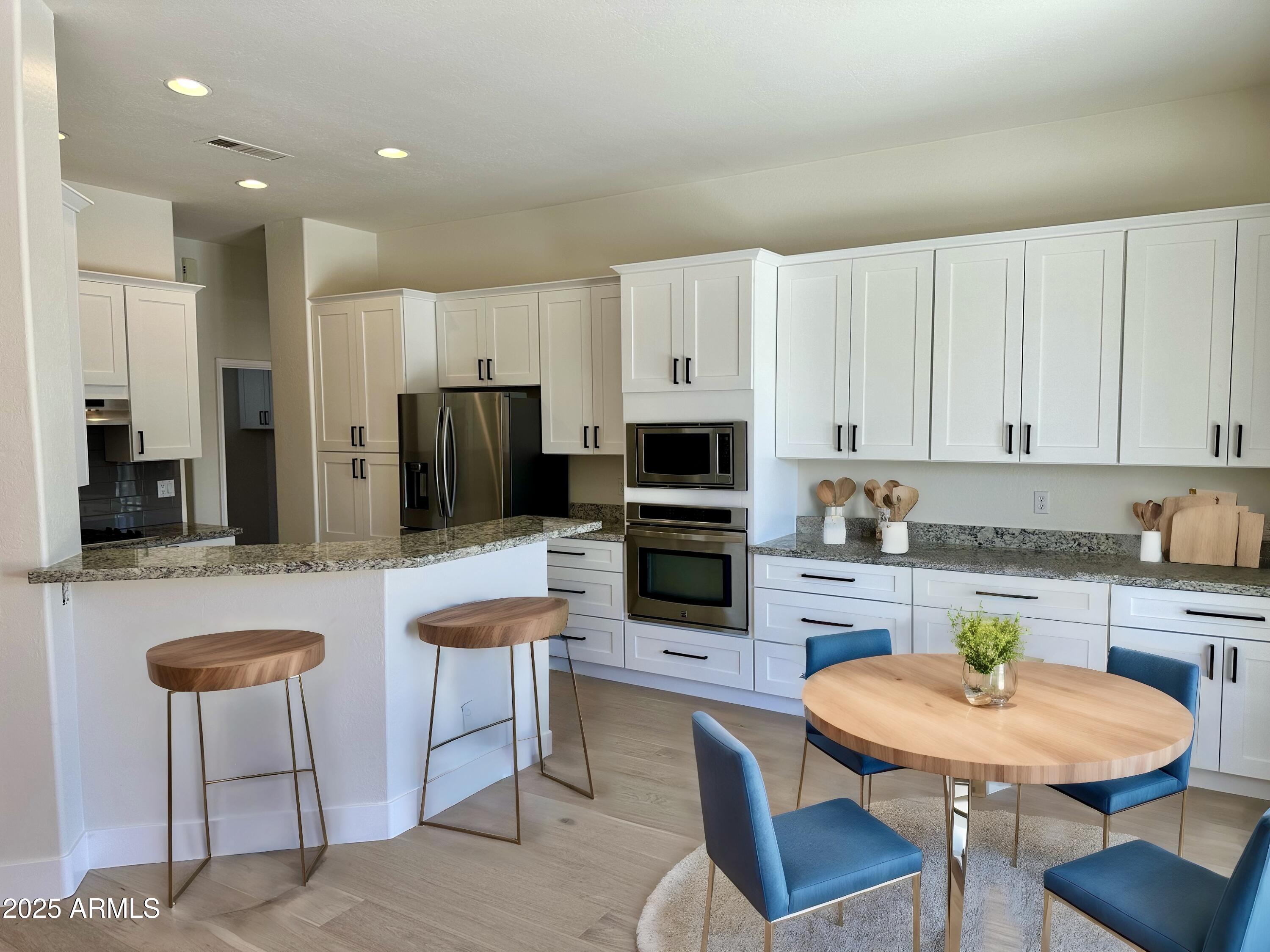 4303 East Hamblin Drive Phoenix, AZ 85050 - Photo 6 of 16 a kitchen with stainless steel appliances granite countertop a stove a sink a microwave a dining table and chairs