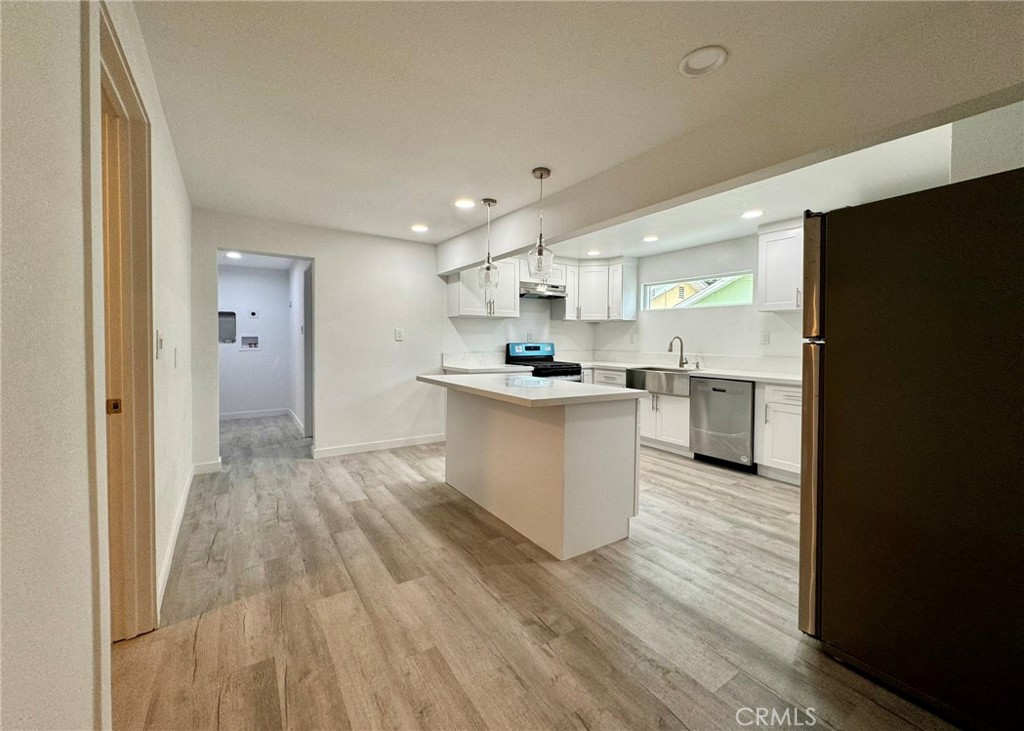 1362 South Downey Road Los Angeles, CA 90023 - Photo 10 of 30 a kitchen with stainless steel appliances granite countertop a refrigerator a sink dishwasher and a oven with wooden floor