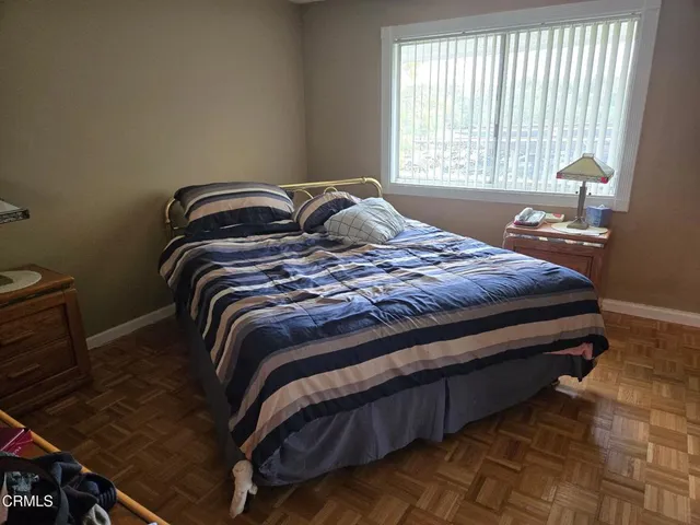 a bed sitting in a bedroom next to a window