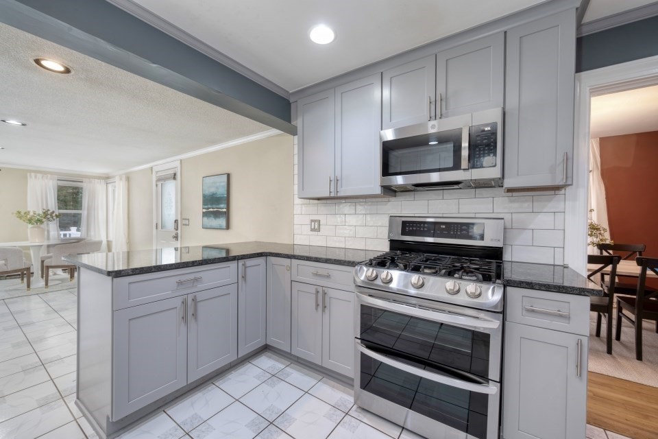 193 Vincent Road Dedham, MA 02026 - Photo 14 of 42 a kitchen with stainless steel appliances a stove sink microwave and cabinets