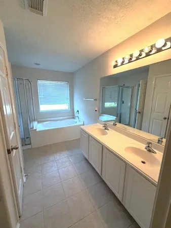 a spacious bathroom with a tub a sink and a vanity