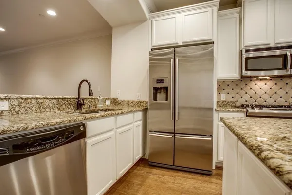 a kitchen with stainless steel appliances granite countertop a refrigerator and a stove