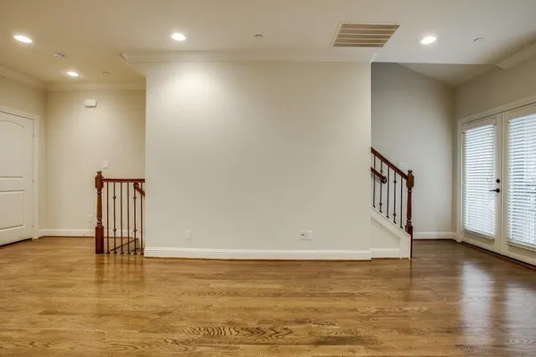 a view of empty room with wooden floor and chair
