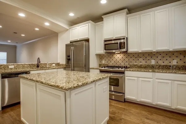 a kitchen with stainless steel appliances granite countertop a sink stove and refrigerator