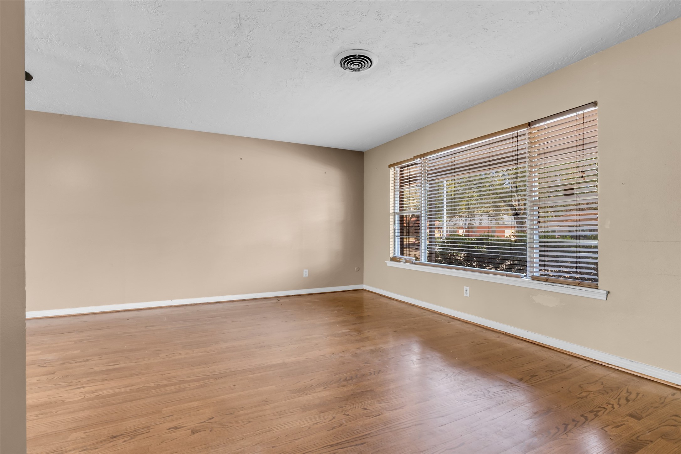 4825 Ella Boulevard Houston, TX 77018 - Photo 5 of 27 a view of an empty room with wooden floor and a window