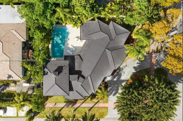 a front view of a house with a garden and trees