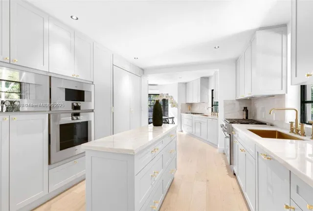 a kitchen with white cabinets and stainless steel appliances