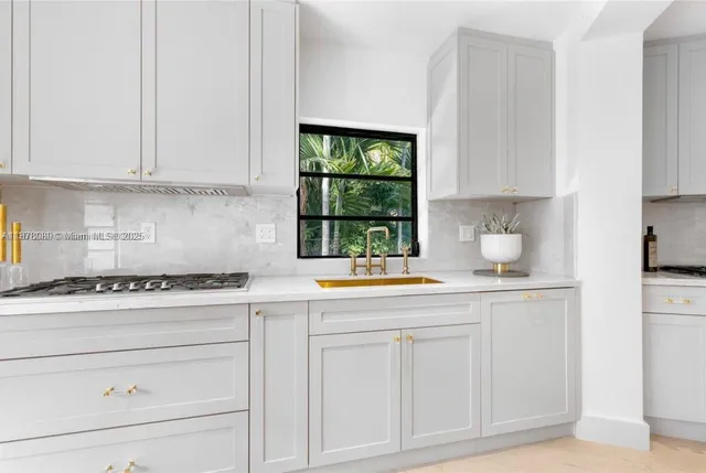 a kitchen with granite countertop white cabinets and window