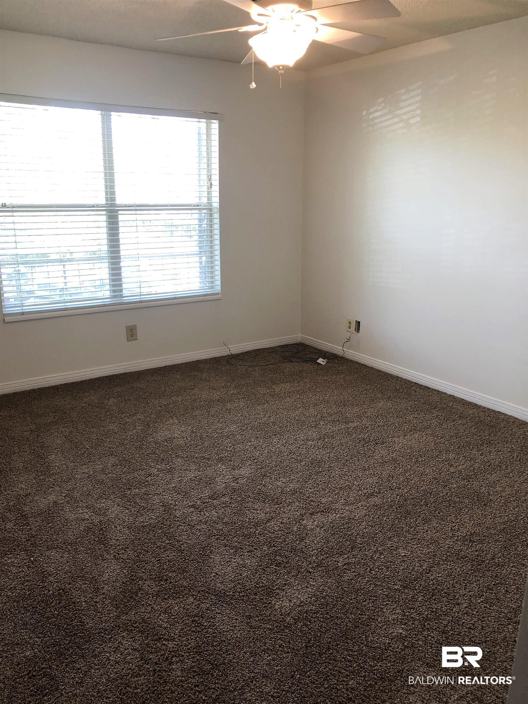 4009 Old Shell Road, Unit C12 Mobile, AL 36608 - Photo 8 of 11 Unfurnished room featuring dark colored carpet and ceiling fan