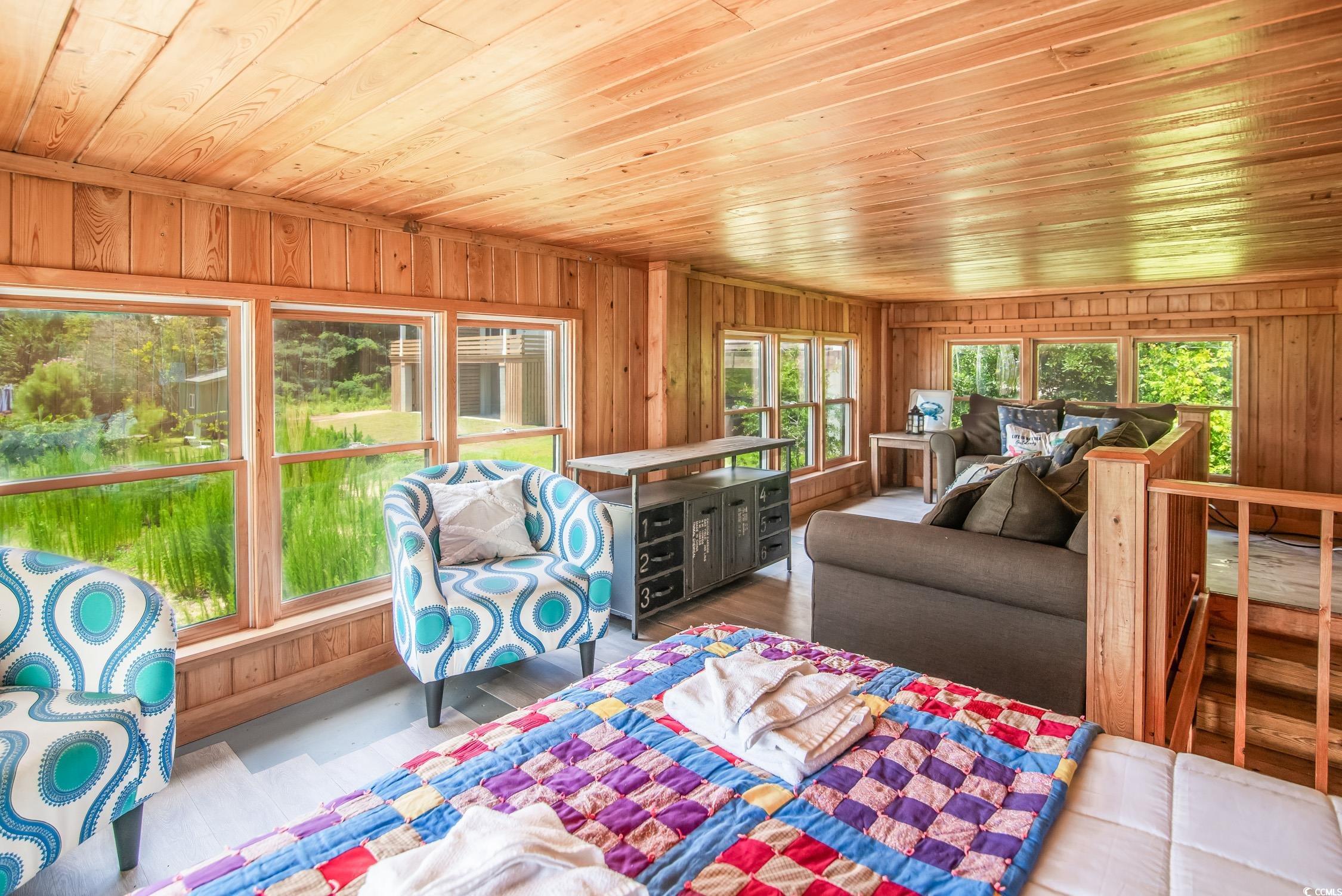 127 Brown Pelican Loop Pawleys Island, SC 29585 - Photo 11 of 31 Living room featuring wooden ceiling, wood walls, and wood finished floors