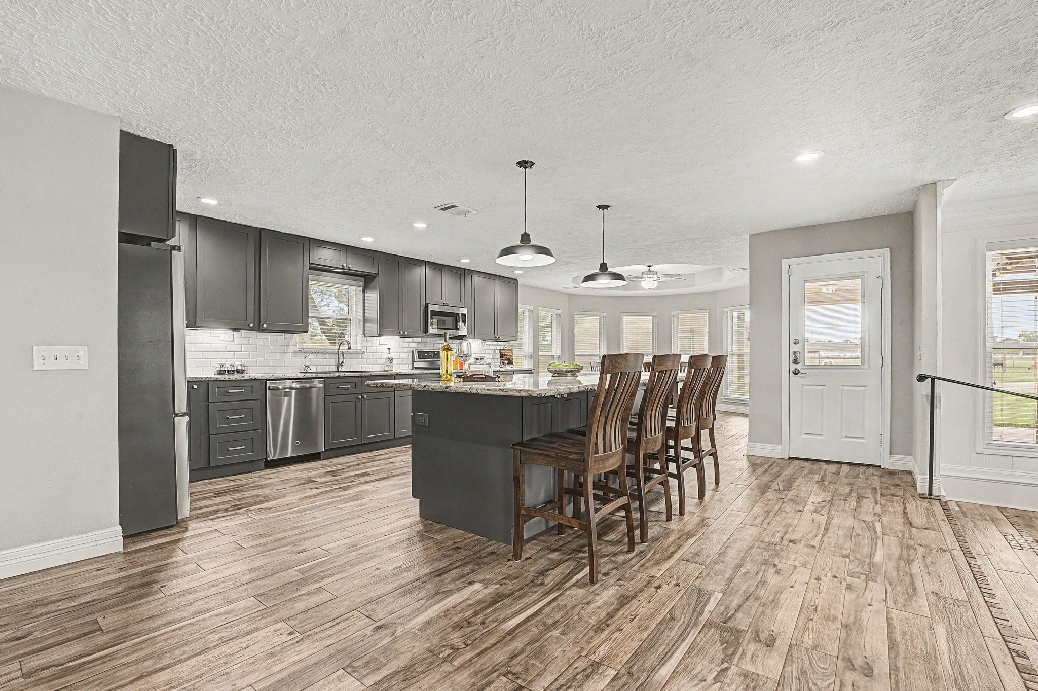 35564 Brumlow Road Hempstead, TX 77445 - Photo 8 of 46 a kitchen with stainless steel appliances kitchen island granite countertop a table chairs in it and wooden floors