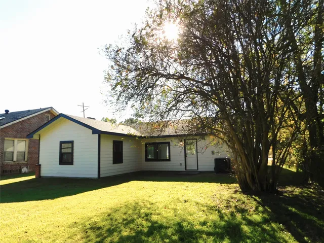 a front view of a house with a large tree
