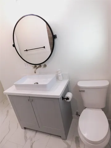 a bathroom with a sink a toilet and mirror
