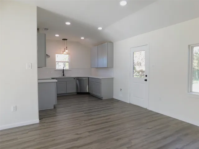 a view of a kitchen with a sink and wooden floor