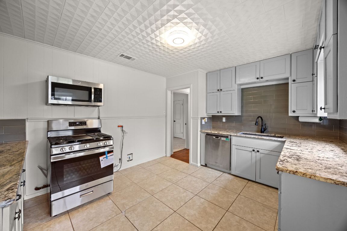 1815 Eckhardt Street Taylor, TX 76574 - Photo 17 of 33 a kitchen with a stove a sink and a refrigerator
