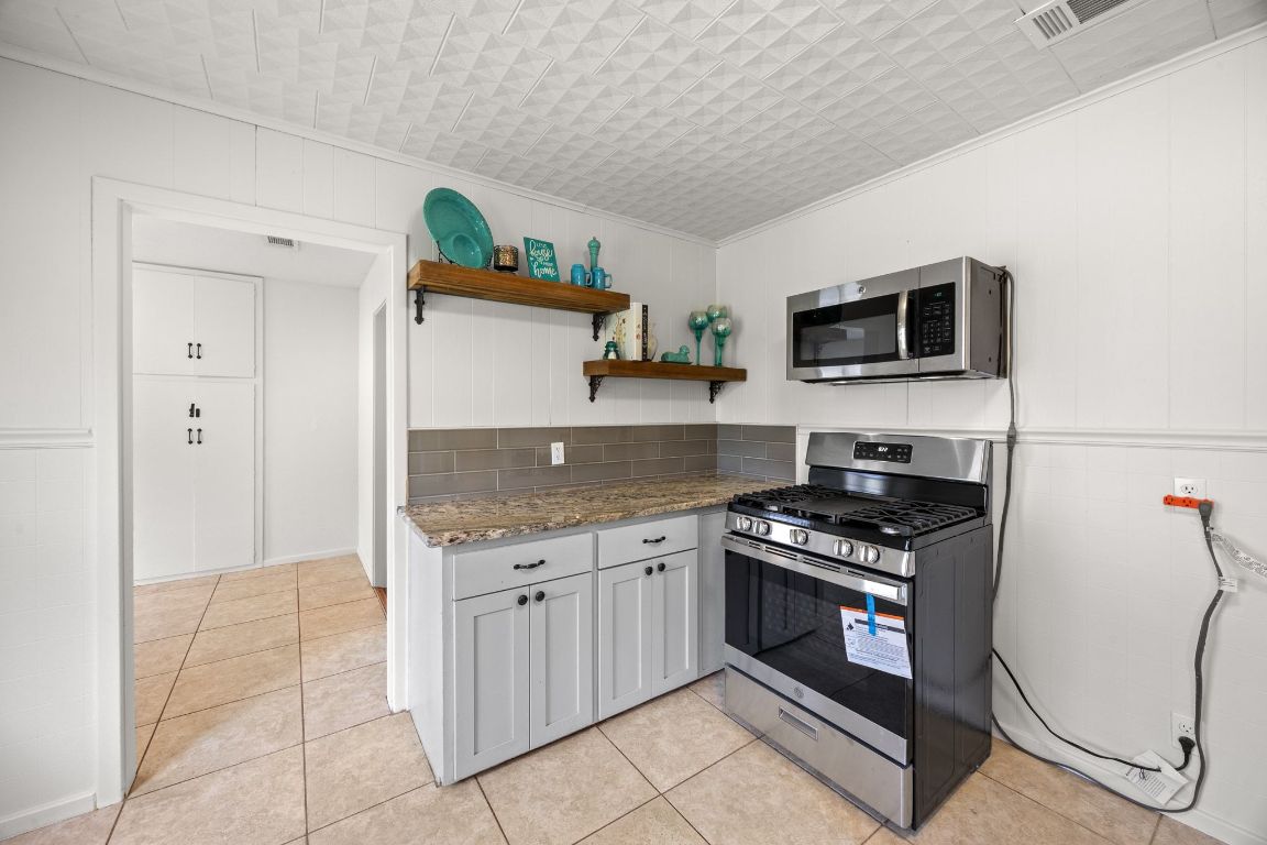1815 Eckhardt Street Taylor, TX 76574 - Photo 19 of 33 a kitchen with stainless steel appliances a stove a sink and a microwave