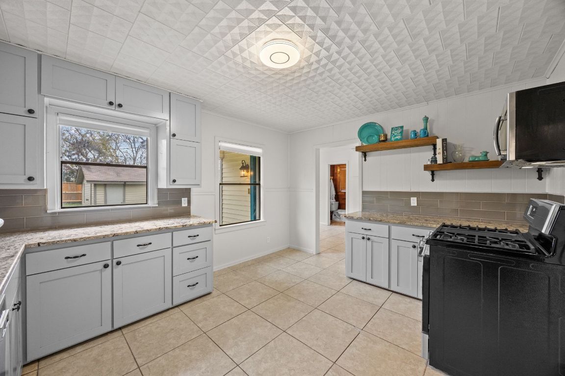 1815 Eckhardt Street Taylor, TX 76574 - Photo 20 of 33 a kitchen with granite countertop cabinets a sink a stove and a refrigerator