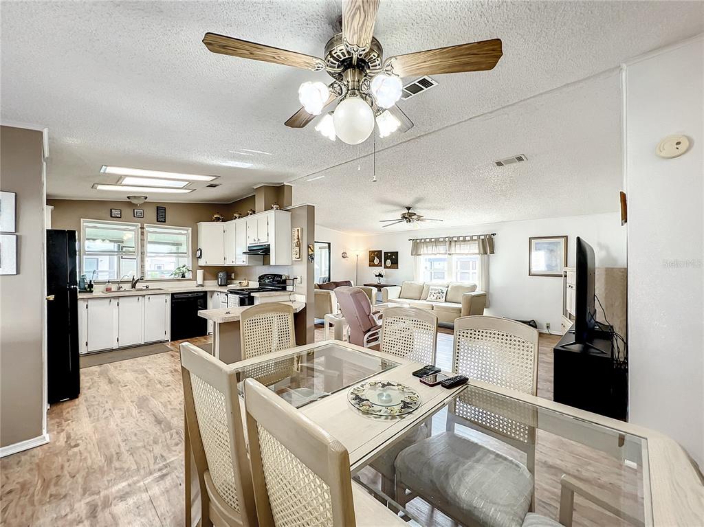 6518 Raintree Lane Winter Haven, FL 33881 - Photo 12 of 42 a living room with stainless steel appliances kitchen island granite countertop furniture and a view of kitchen