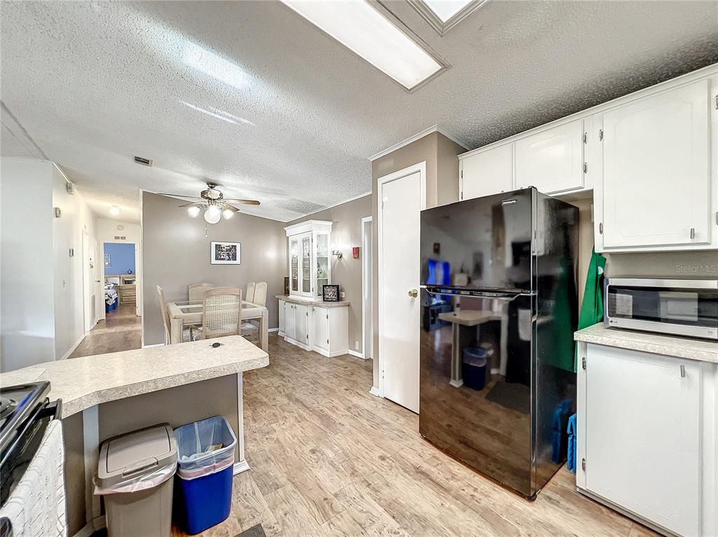 6518 Raintree Lane Winter Haven, FL 33881 - Photo 14 of 42 a large kitchen with a table chairs refrigerator and a sink