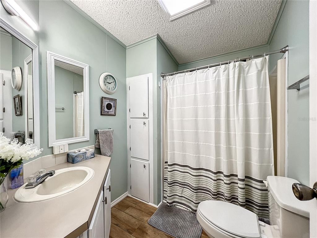 6518 Raintree Lane Winter Haven, FL 33881 - Photo 19 of 42 a bathroom with a sink a toilet and shower curtain