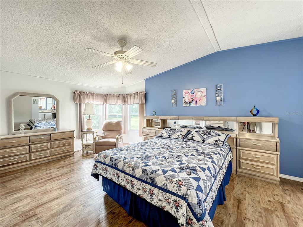 6518 Raintree Lane Winter Haven, FL 33881 - Photo 21 of 42 a bedroom with a large bed and a chandelier