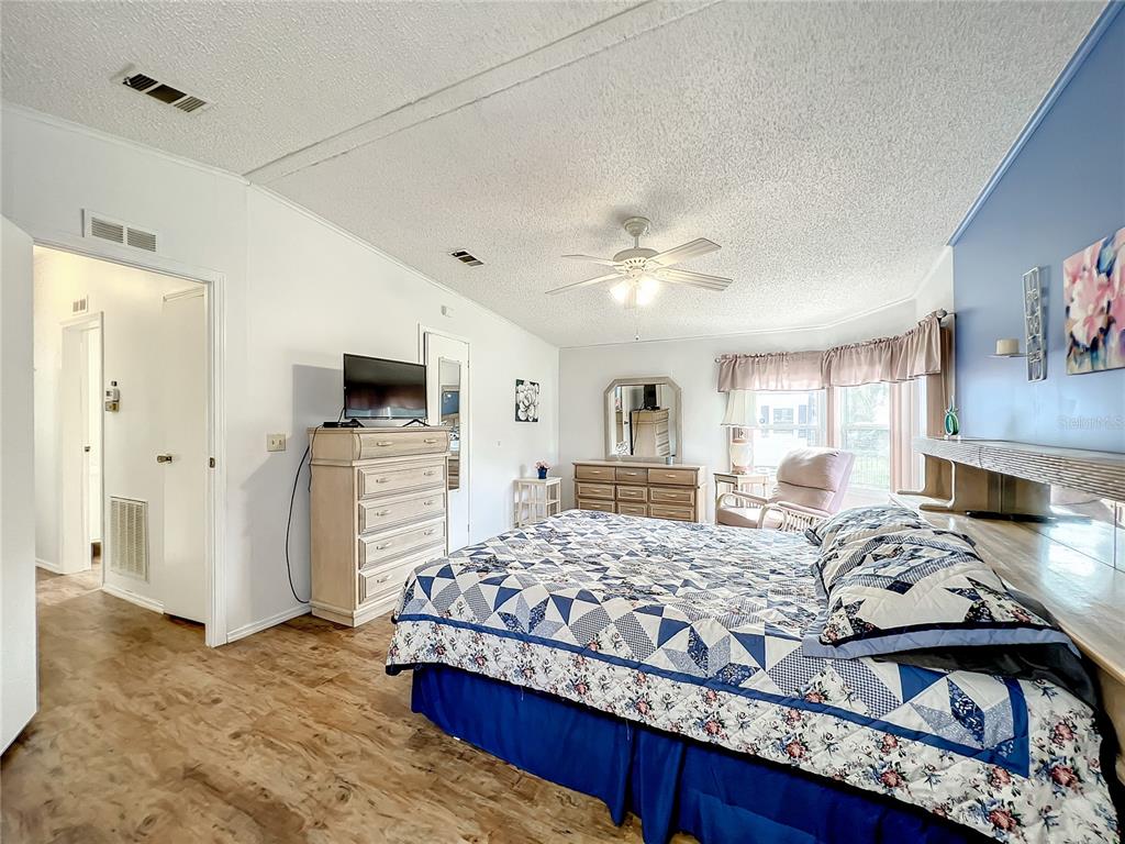 6518 Raintree Lane Winter Haven, FL 33881 - Photo 22 of 42 a bedroom with a bed and a view of kitchen