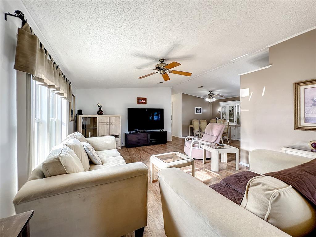 6518 Raintree Lane Winter Haven, FL 33881 - Photo 9 of 42 a living room with furniture a fireplace and a flat screen tv