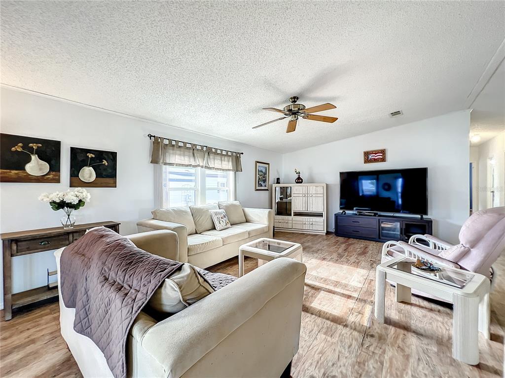 6518 Raintree Lane Winter Haven, FL 33881 - Photo 10 of 42 a living room with furniture a flat screen tv and a window