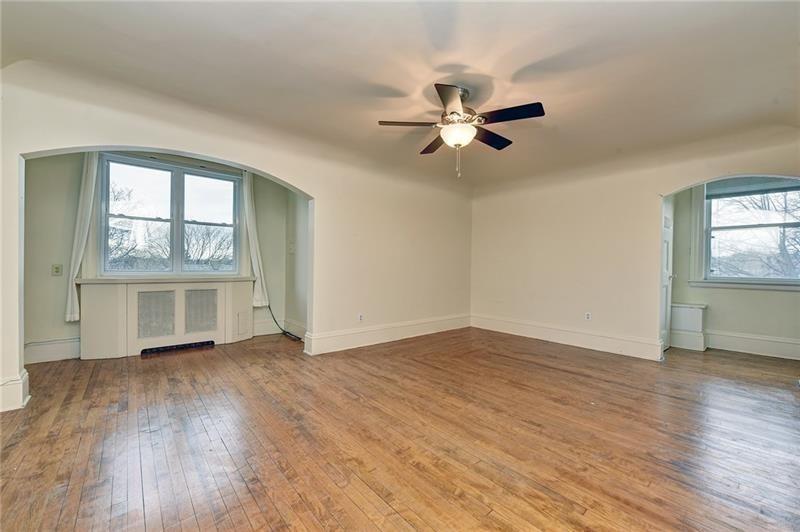 6316 Morrowfield Avenue, Unit 3 Pittsburgh, PA 15217 - Photo 4 of 14 an empty room with wooden floor fan and windows