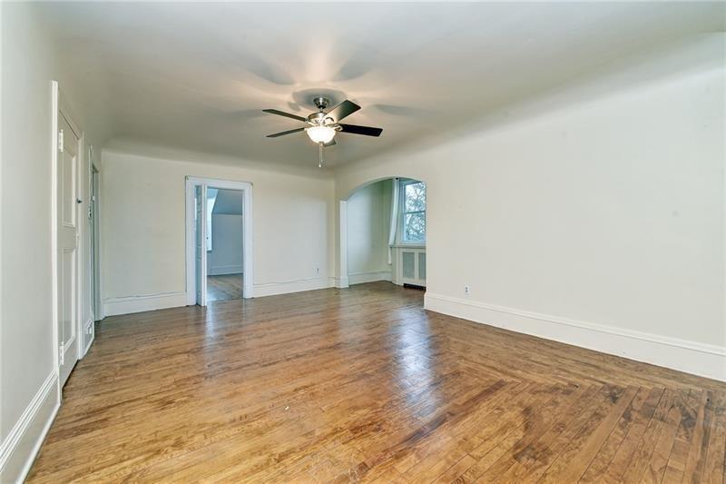 6316 Morrowfield Avenue, Unit 3 Pittsburgh, PA 15217 - Photo 5 of 14 an empty room with wooden floor and ceiling fan