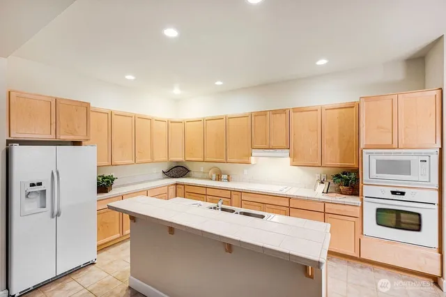 a kitchen with stainless steel appliances granite countertop a refrigerator sink and cabinets