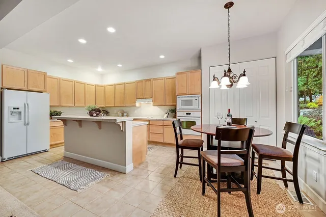 a view of a dining room and livingroom with furniture wooden floor a chandelier