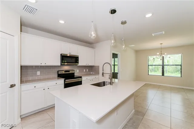 a kitchen with a sink a counter top space stainless steel appliances and cabinets