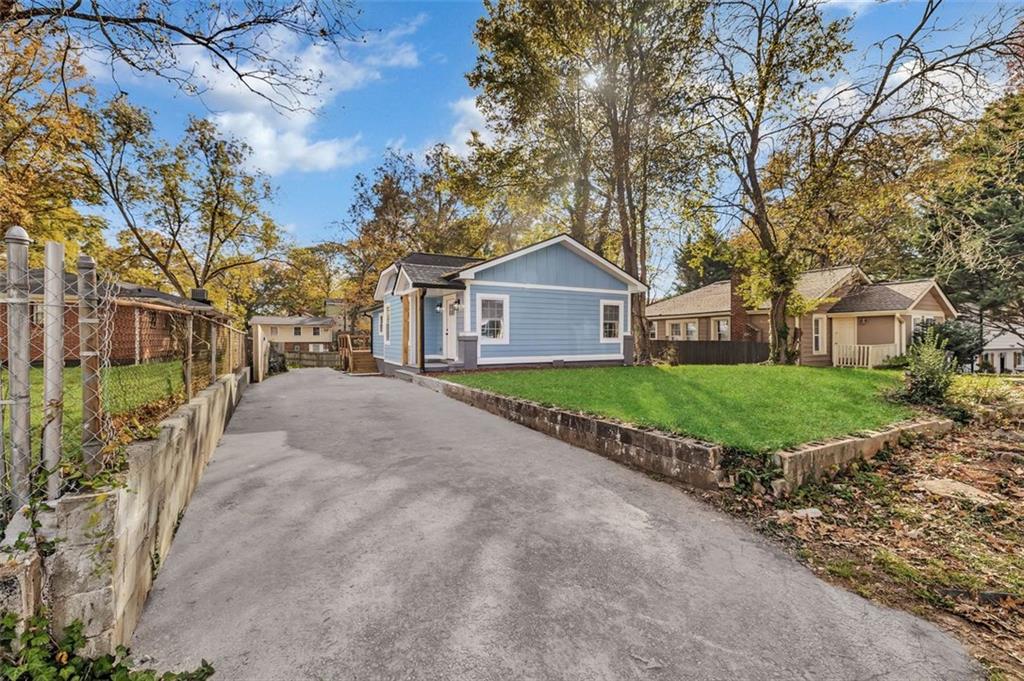 1874 Phillips Avenue East Point, GA 30344 - Photo 2 of 19 a view of a white house with a big yard and large trees