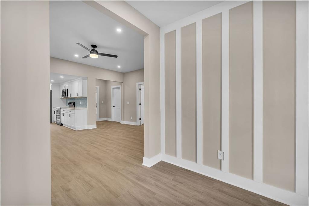 1874 Phillips Avenue East Point, GA 30344 - Photo 5 of 19 a view of an empty room and kitchen space with wooden floor