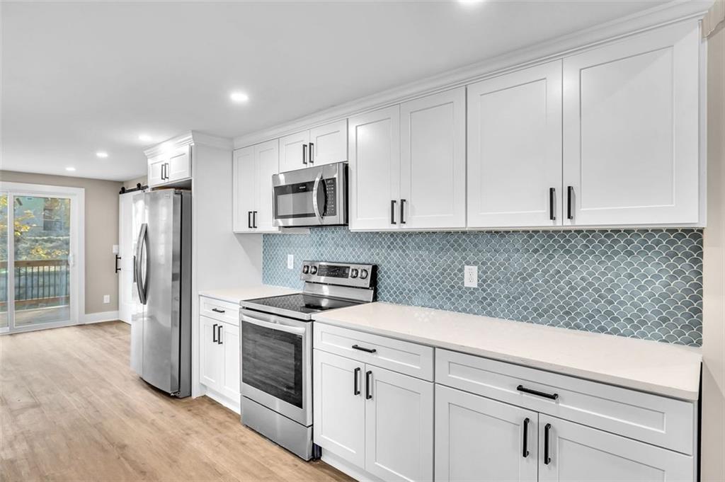 1874 Phillips Avenue East Point, GA 30344 - Photo 9 of 19 a kitchen with granite countertop white cabinets and stainless steel appliances