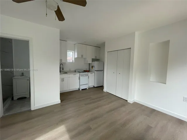 a view of a kitchen with a sink and dishwasher a refrigerator with wooden floor