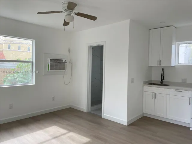 a kitchen with a sink cabinets and wooden floor