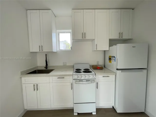 a kitchen with cabinets and white appliances